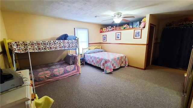 carpeted bedroom featuring baseboards and ceiling fan