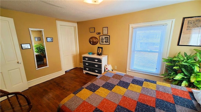 bedroom featuring dark wood-style floors, a textured ceiling, and baseboards