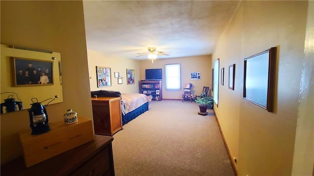 bedroom featuring a ceiling fan, baseboards, and light carpet