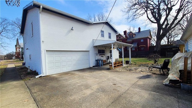 view of side of home featuring concrete driveway and a garage