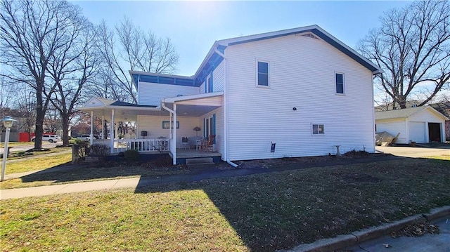 view of home's exterior featuring an outbuilding, a porch, and a yard