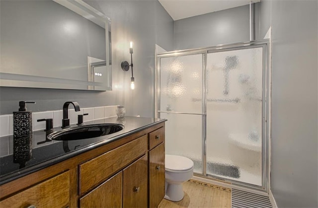 full bath featuring toilet, a shower stall, wood finished floors, and vanity