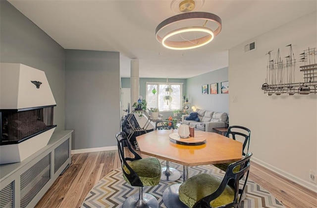 dining room featuring visible vents, baseboards, and wood finished floors