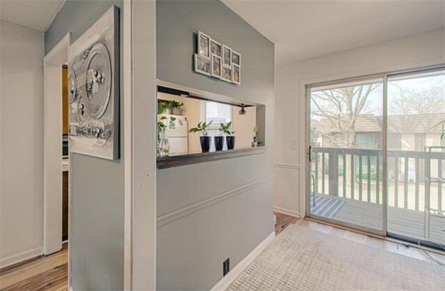 hallway featuring baseboards and wood finished floors