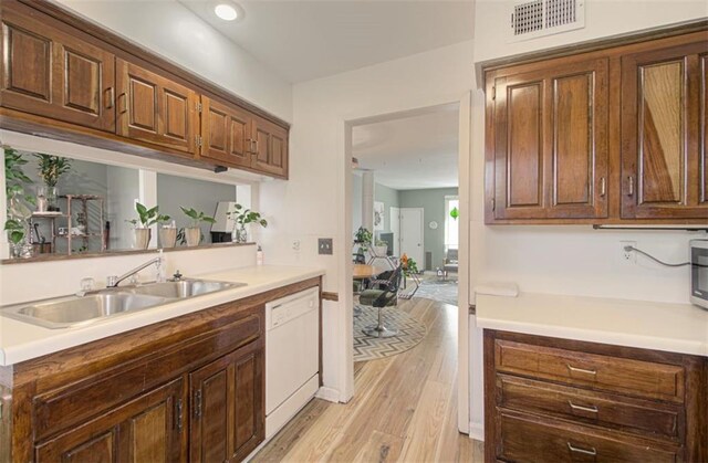 kitchen with light countertops, visible vents, dishwasher, and light wood-style flooring