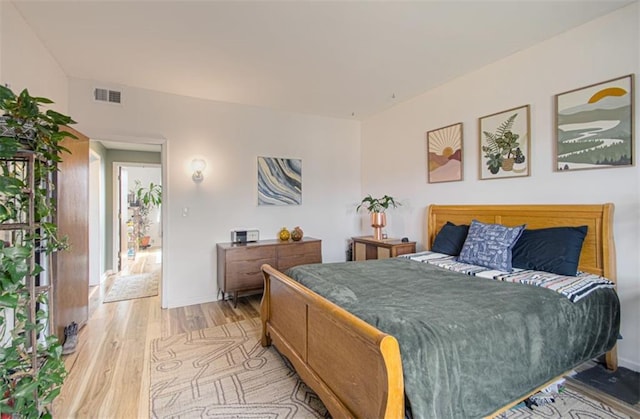 bedroom with light wood-style floors, baseboards, and visible vents