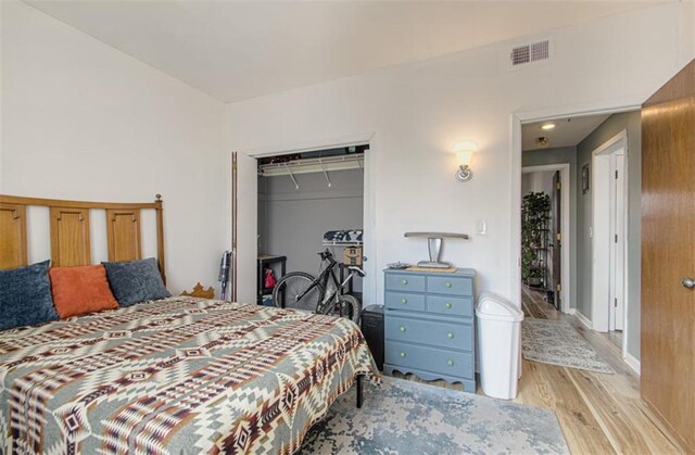 bedroom featuring a closet, visible vents, and wood finished floors