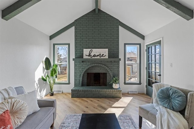 living area with lofted ceiling with beams, baseboards, and wood finished floors