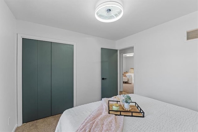 carpeted bedroom featuring a closet and visible vents