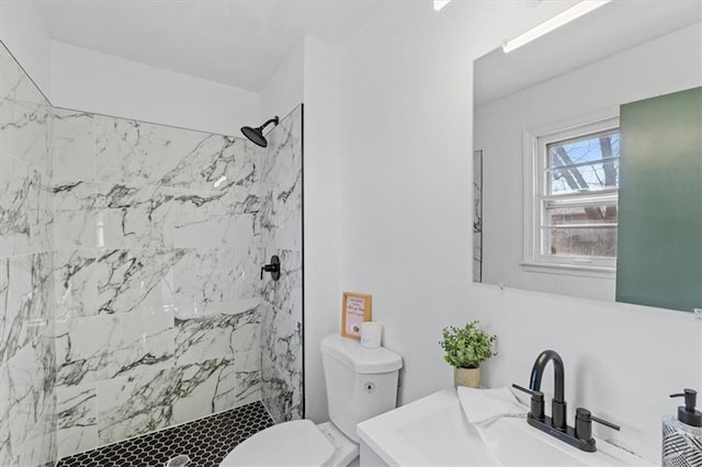 full bath with a sink, a marble finish shower, and toilet