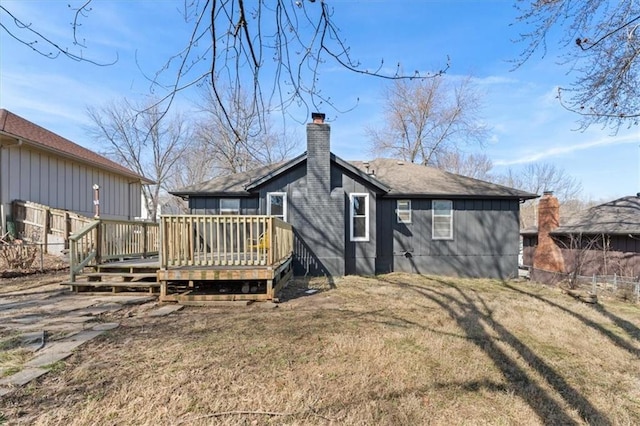 rear view of property with a wooden deck, a lawn, fence, and a chimney