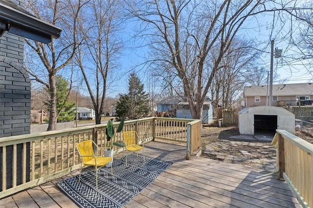 wooden terrace with an outbuilding, a shed, a residential view, and fence