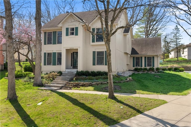 view of front of home featuring a front lawn and roof with shingles