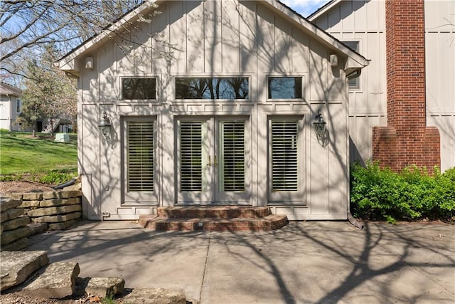 rear view of property featuring entry steps, board and batten siding, and a patio area