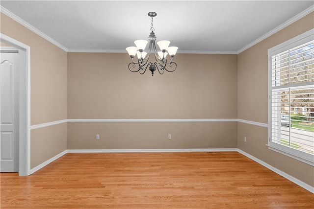 empty room with a wealth of natural light, a notable chandelier, light wood-style floors, and crown molding