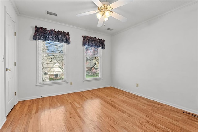 empty room featuring baseboards, light wood-style floors, visible vents, and ornamental molding