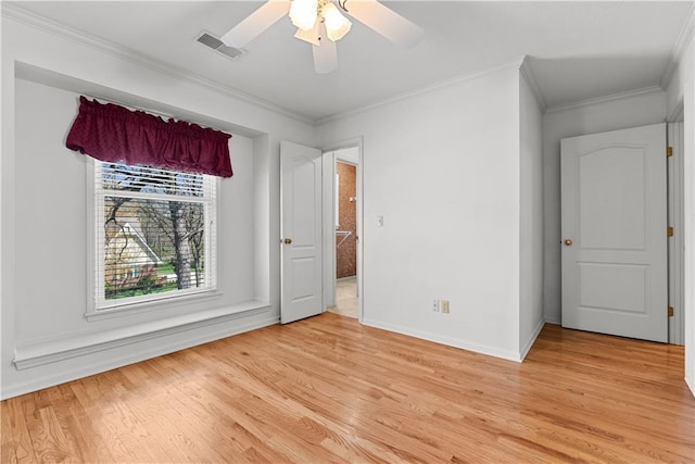 interior space featuring light wood-style floors, visible vents, baseboards, and crown molding