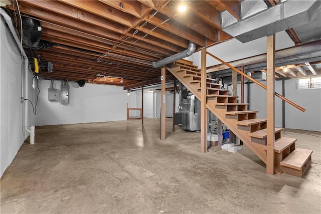 below grade area with heating unit, electric panel, and stairs