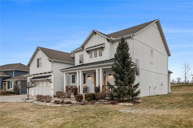 modern farmhouse style home with a garage, covered porch, a front yard, and a standing seam roof