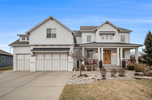 modern farmhouse with covered porch, an attached garage, board and batten siding, a standing seam roof, and driveway