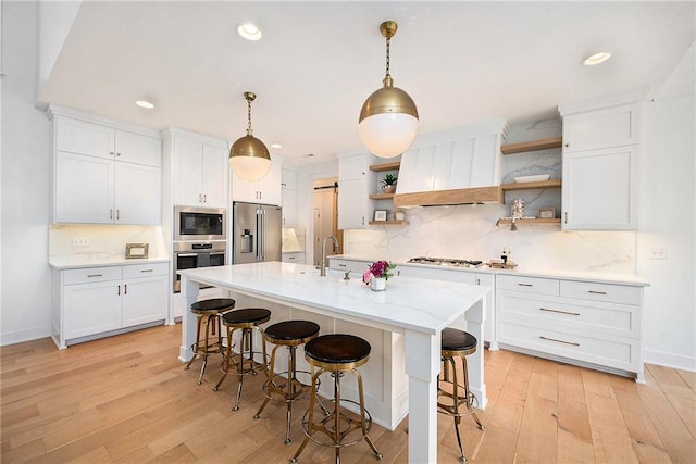 kitchen with custom exhaust hood, stainless steel appliances, light wood-style floors, open shelves, and backsplash