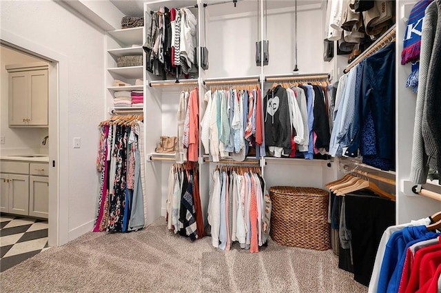 walk in closet with carpet floors and a sink