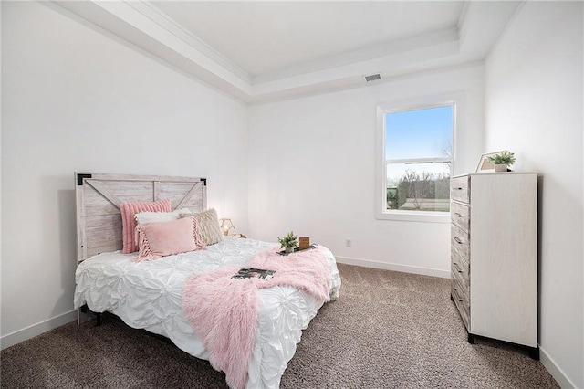 carpeted bedroom featuring baseboards, visible vents, a raised ceiling, and ornamental molding