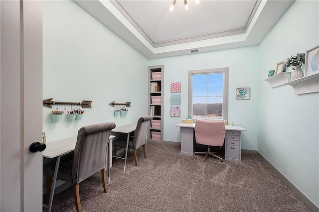 carpeted home office with a raised ceiling and visible vents