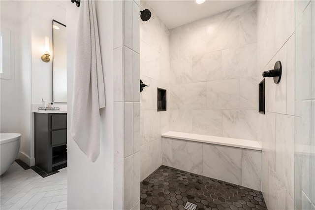 full bath with a tile shower and vanity