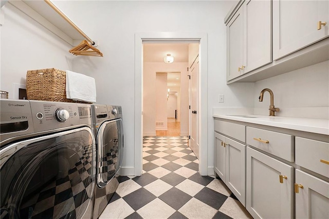 laundry room with cabinet space, a sink, washer and dryer, baseboards, and tile patterned floors