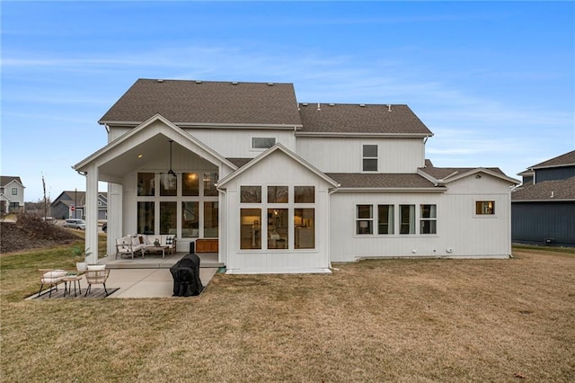 rear view of house with a yard, a patio, a shingled roof, and ceiling fan