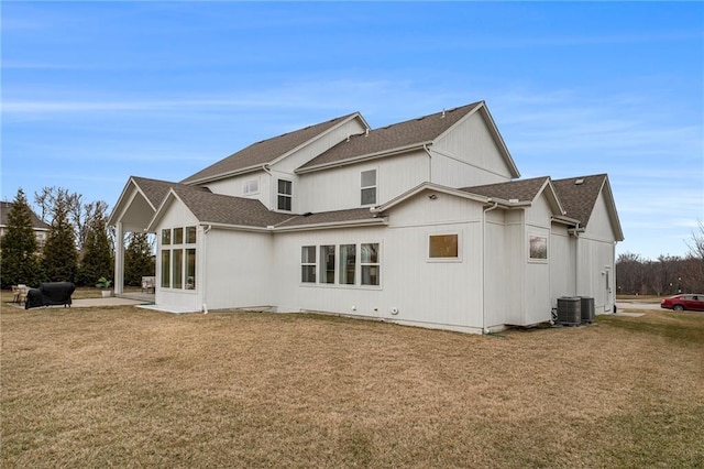 back of house with a yard, a patio, and roof with shingles