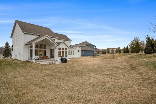 rear view of house featuring a lawn and a patio