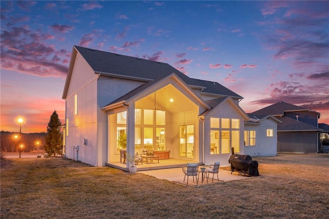 rear view of property featuring a lawn and a patio area