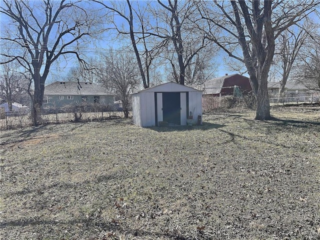 view of yard with an outdoor structure, a storage shed, and fence