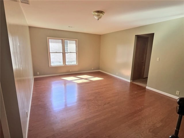 spare room featuring wood finished floors and baseboards