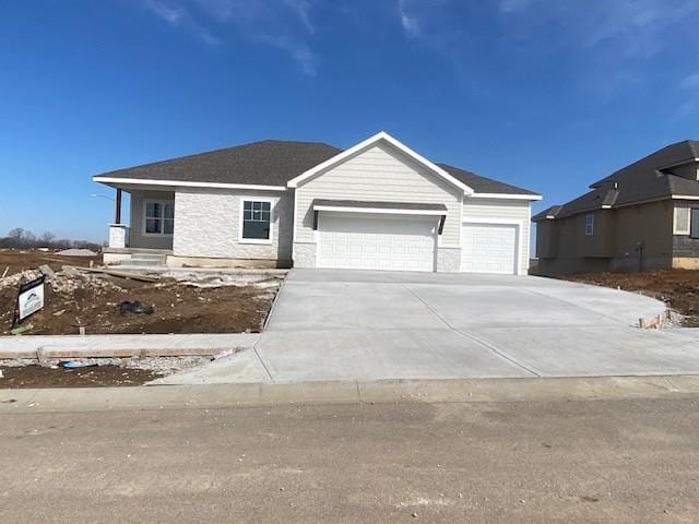 view of front of home with stone siding, concrete driveway, and an attached garage