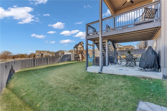 view of yard featuring a playground, a fenced backyard, stairway, a wooden deck, and a patio area