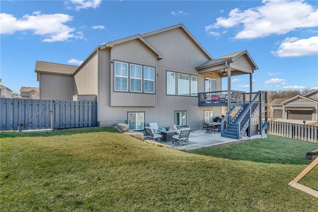 back of house with stairs, a patio, a yard, and a fenced backyard