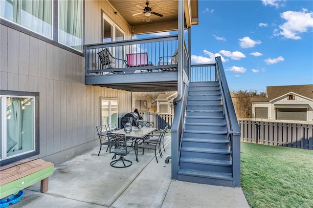 view of patio with ceiling fan, outdoor dining area, stairway, and fence