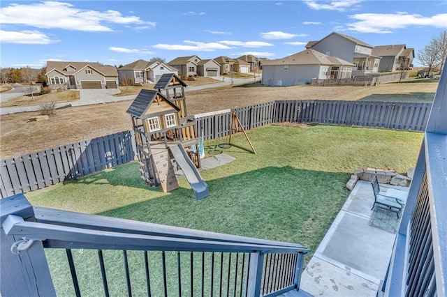 view of jungle gym featuring a yard, a fenced backyard, and a residential view