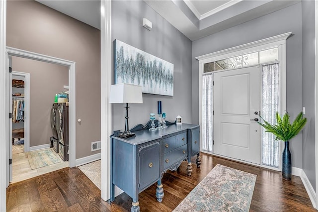 foyer entrance featuring dark wood-style floors, a wealth of natural light, visible vents, and baseboards