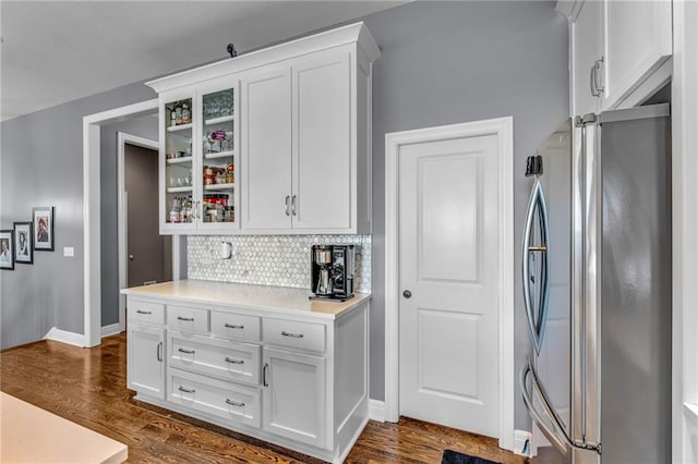 kitchen with dark wood-style floors, freestanding refrigerator, and white cabinetry