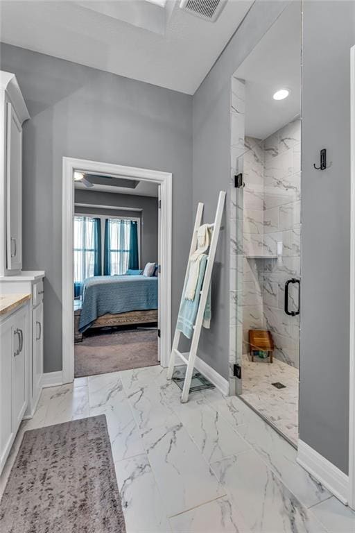 bathroom with marble finish floor, a marble finish shower, baseboards, and ensuite bathroom