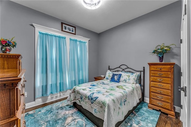 bedroom featuring baseboards and wood finished floors