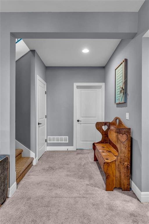 sitting room with stairway, baseboards, visible vents, and carpet flooring