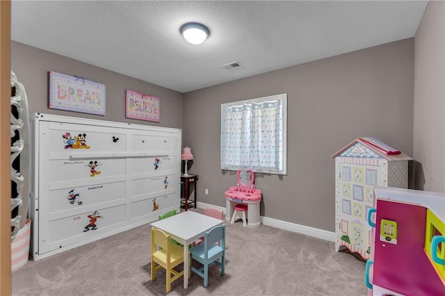 recreation room with carpet, visible vents, a textured ceiling, and baseboards