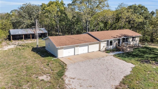 view of front of home featuring an attached garage, a front yard, and gravel driveway