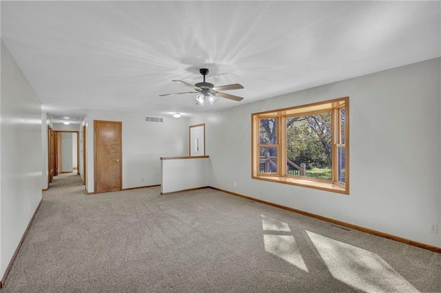 unfurnished room featuring visible vents, ceiling fan, light carpet, and baseboards