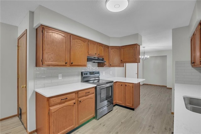 kitchen featuring stainless steel range with electric stovetop, light countertops, light wood-style floors, and under cabinet range hood